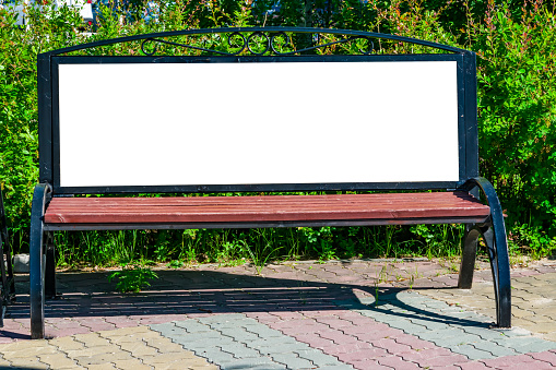 Billboard with blank white copy space for text message or content, mock up banner near the buildings lit by sunlight