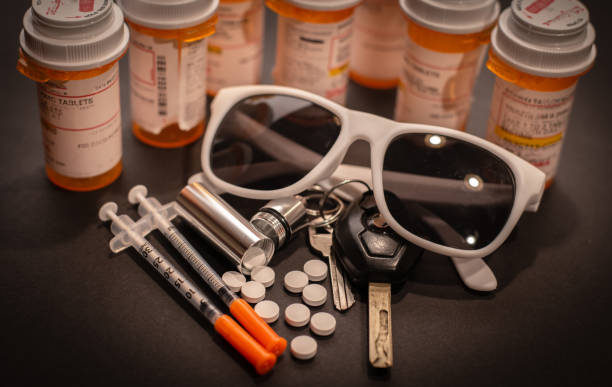 Pills, Keys and Sunglasses Pills are strewn out of a cylindrical container attached to a keyring. fentanyl addiction stock pictures, royalty-free photos & images