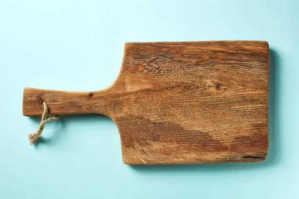 istock Wooden cutting board on blue background, from above 1013497274