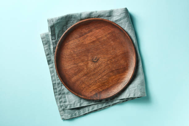 istock Wooden plate on blue background, from above 1013498540