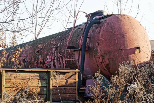 część dużej starej cysterny zardzewiałej i czerwonej na zewnątrz w suchej trawie - rusty storage tank nobody photography zdjęcia i obrazy z banku zdjęć