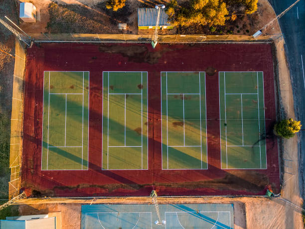 istock Looking down at old tennis courts at sunset - aerial view 1013507098