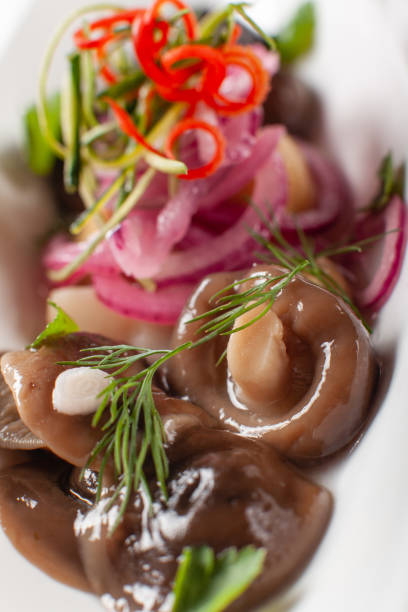 istock White plate with marinated lactarius and parsley on table. 1013517724