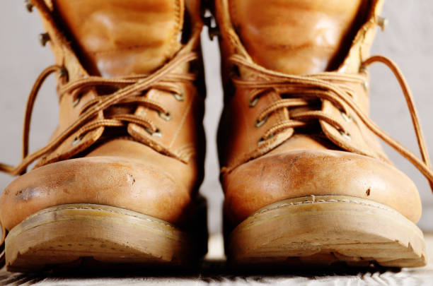 istock Yellow leather used work boots on concrete background closeup. Place for text 1013521544
