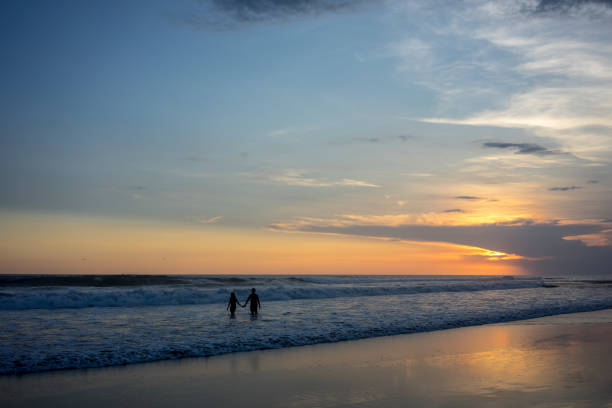 istock couple on beach at sunset, romantic mood 1013521610