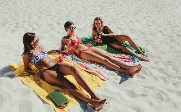 istock Women sunbathing on beach 1013536194