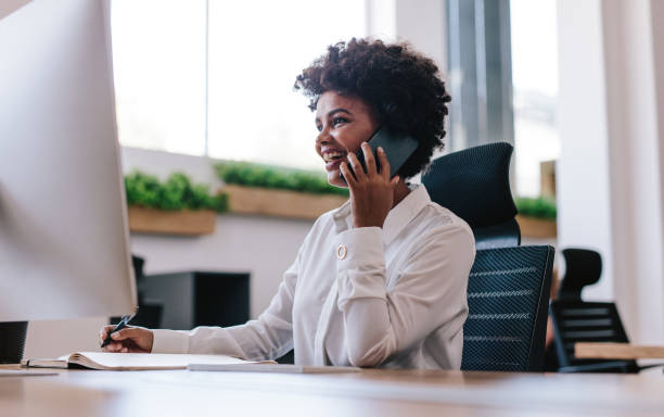 istock Smiling businesswoman talking with client over phone 1013541946