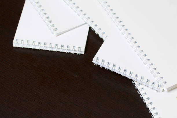 istock White spring notebooks for notes and sketches. Stationery for school and teaching. On a dark background. 1013542442