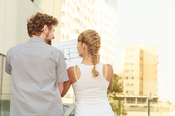 istock couple with blueprint project  building plans outdoor 1013542656
