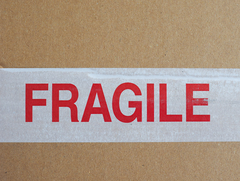 fragile warning tape on brown corrugated cardboard