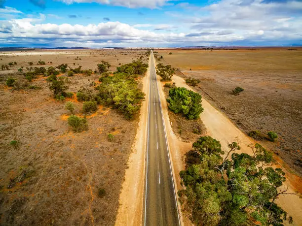 Aerial view of straight rural road leading to horizon under beautiful skies in South Australia