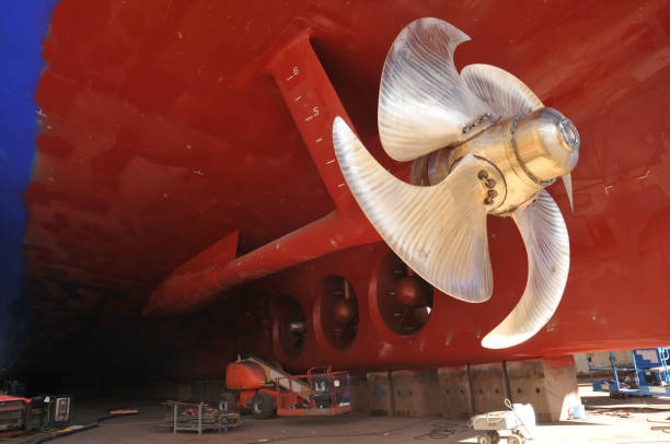 propeller under reconstruction. under the ship. big ship under repairing on dry dock in shipyard - old crane blue sky imagens e fotografias de stock