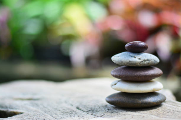 istock Zen stones on gray rock with blossom bokeh background left space position. 1013574100