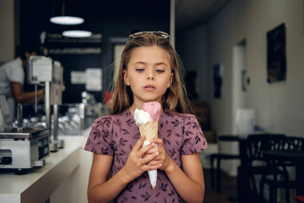 istock A girl eating ice cream in a cafe. 1013587568