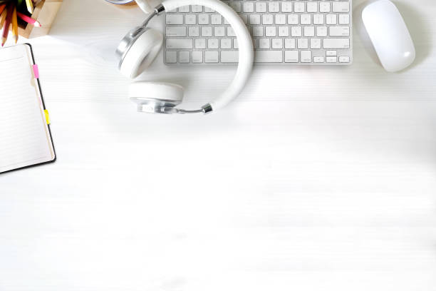 istock Workspace with computer, headphones, colour pencils and coffee mug on white wooden background. Flat lay, top view 1013596508