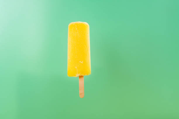 istock yellow popsicle on a light green background 1013606626