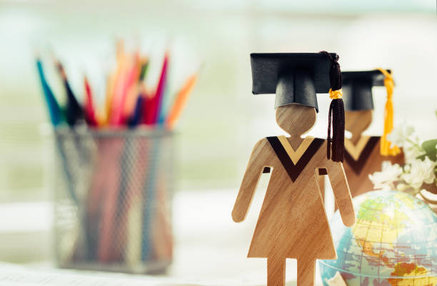istock Education knowledge learning study abroad international Ideas. People Sign wood with Graduation celebrating cap on open textbook, America global map show alternative studying Back to School Concept 1013617690