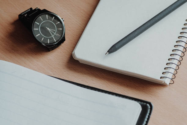 istock Wooden office desk table with two notebooks, pen and watch. 1013624788
