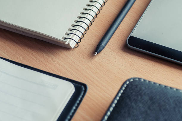 istock Wooden office desk table with two notebooks, graphical tablet and pen. 1013624826