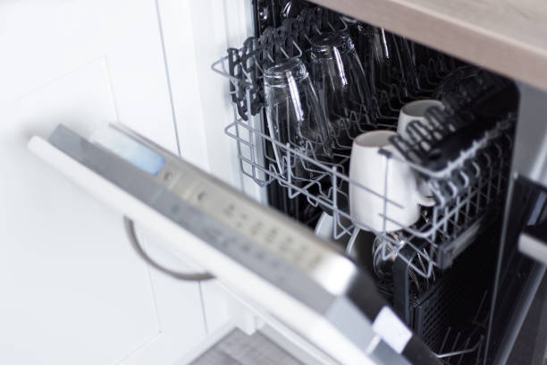 open dishwasher with clean glasses and dishes stock photo