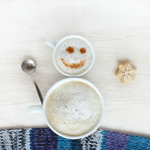 good mood for winter coffee break small and large cup of frothy cappuccino standing together in a cheerful snowman top view froth decoration stock pictures, royalty-free photos & images