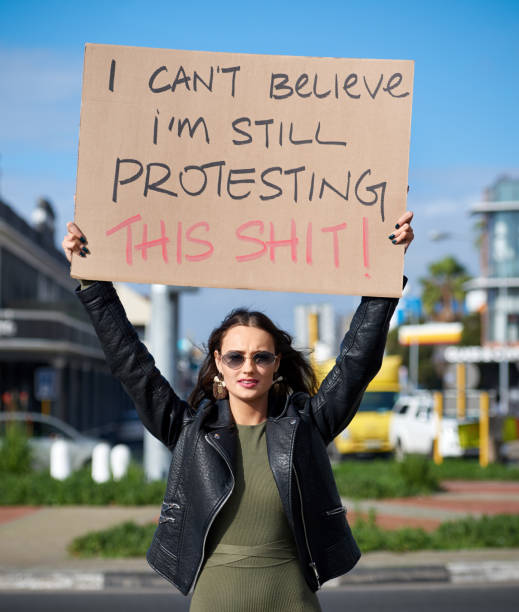 молодая активистка держит в руках знак протеста в городе - cardboard sign стоковые фото и изображения