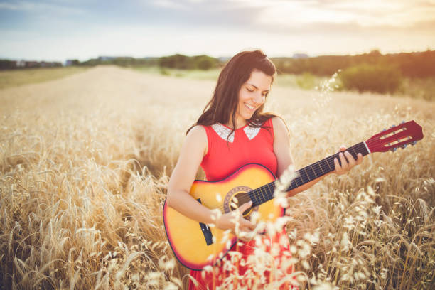 istock Woman plays guitar in a wheat field. 1013633416