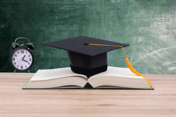 education Black graduated tassel cap placed on the book. dissertation photos stock pictures, royalty-free photos & images