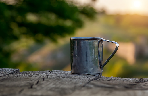 Steel cup on the background of a tourist tent.