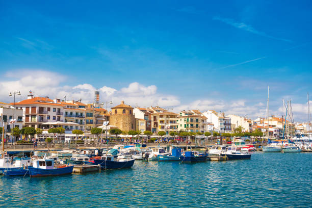 cambrils, espanha - 30 de abril de 2017: vista do porto e a cidade à beira-mar com a igreja de são pedro, no meio e torre del porto. copie o espaço para texto - sailboat moored blue nautical vessel - fotografias e filmes do acervo