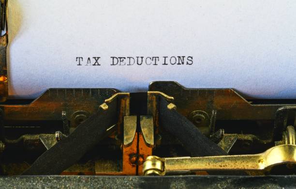 istock Closeup on vintage typewriter. Front focus on letters making TAX DEDUCTIONS text. Business concept image with retro office tool 1013654802