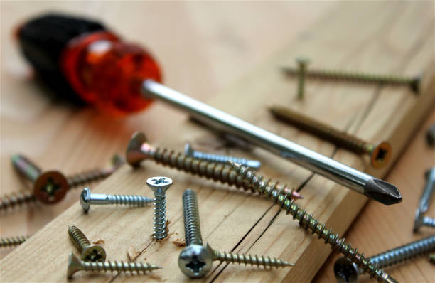 istock screws in a wooden board and screwdriver 1013661264