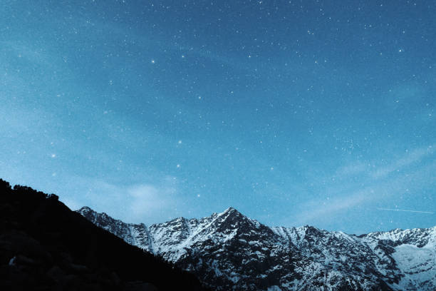 istock Starry sky on a background of snowy mountains 1013672078