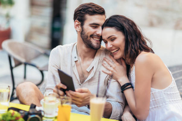 istock Young couple of tourist sitting in a cafe, drinking coffee and using tablet. 1013674792