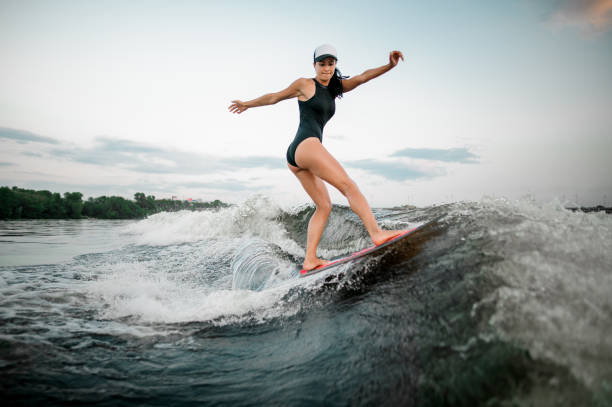 istock Rear view young active woman riding on the wakesurf 1013680272
