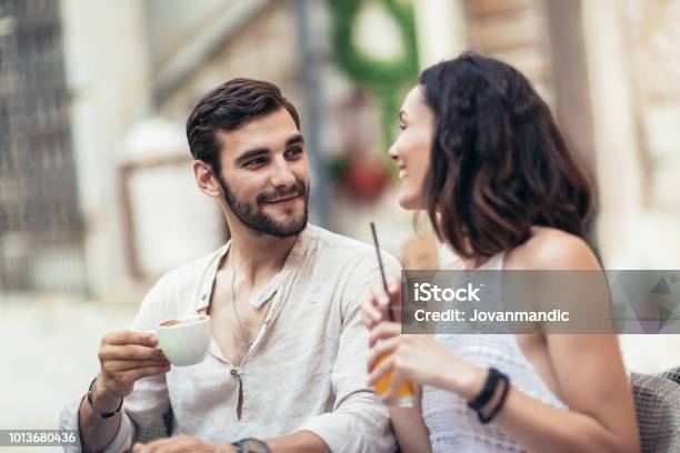 Young Tourists Having Coffee At Cafe And Reading Map Stock Photo - Download Image Now