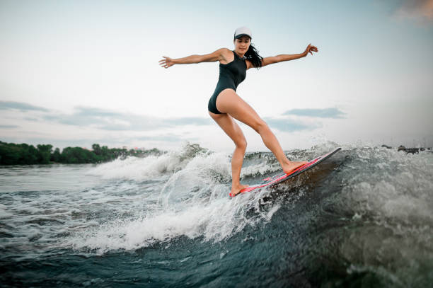 istock Rear view young active girl riding on the wakesurf 1013684574