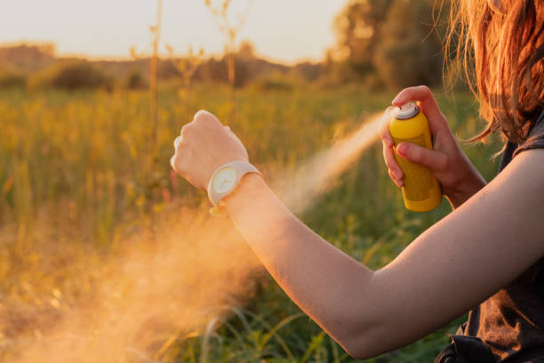 using anti mosquito spray outdoors at hiking trip - insect repellant imagens e fotografias de stock