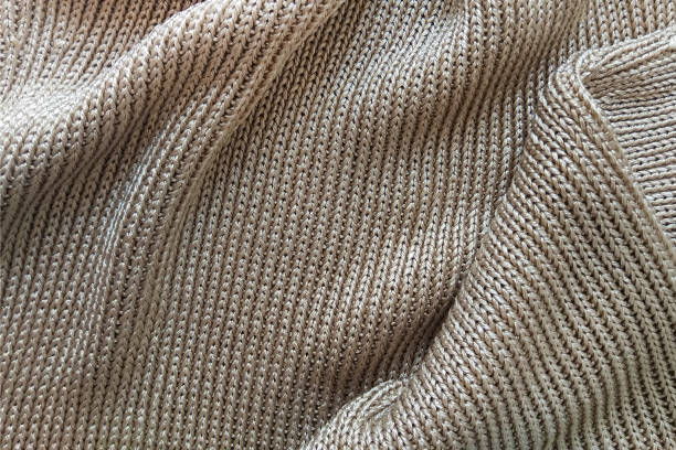 istock Close-up knitted golden silk fabric. Texture abstract background pattern 1013697902