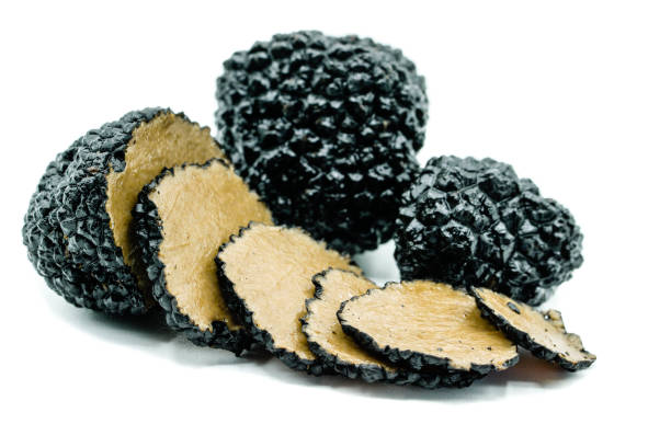istock Two black truffles and one truffle sliced ​​isolated on white background 1013699032