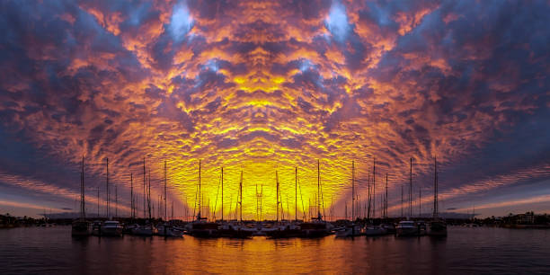 istock Orange colored altocumulus cloud, sunset seascape over marina. 1013707944
