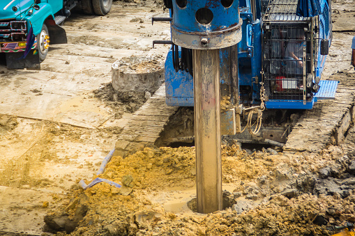 Hydraulic drilling machine is boring holes in the construction site for bored piles work. Bored piles are reinforced concrete elements cast into drilled holes, also known as replacement piles.