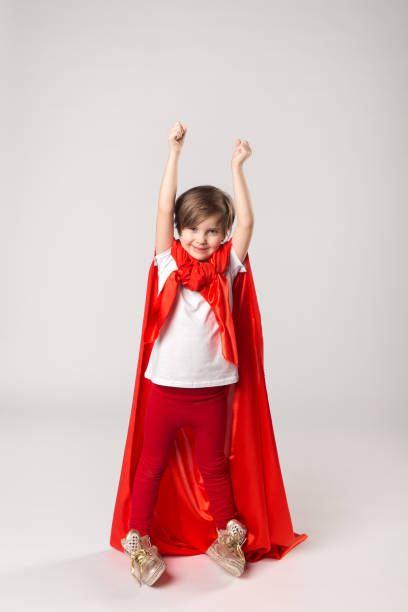 istock Superhero girl in red cape raised her hands up 1013715306