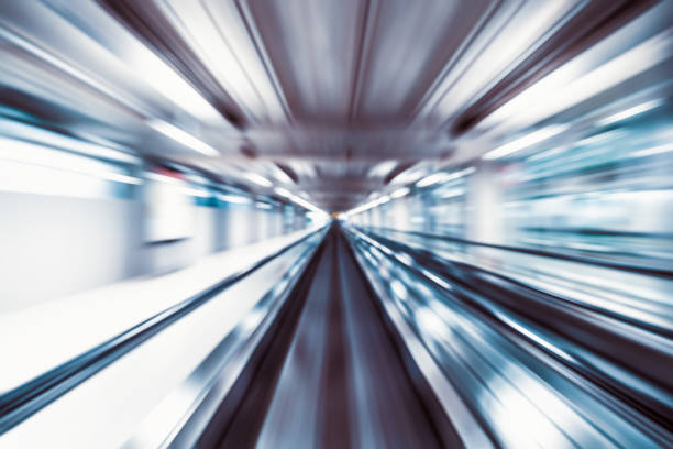 Motion blur abstract background, fast moving walkway or travelator in airport terminal transit, zoom effect, center diminishing perspective. Transportation, warp speed, or business technology concept
