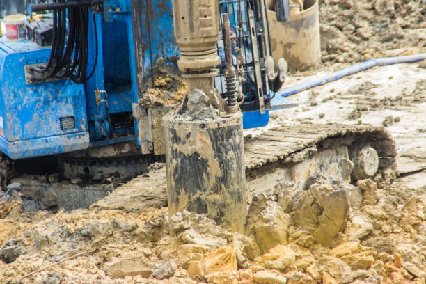 istock Hydraulic drilling machine is boring holes in the construction site for bored piles work. Bored piles are reinforced concrete elements cast into drilled holes, also known as replacement piles. 1013719044