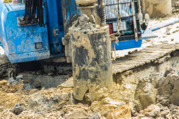 istock Hydraulic drilling machine is boring holes in the construction site for bored piles work. Bored piles are reinforced concrete elements cast into drilled holes, also known as replacement piles. 1013719186