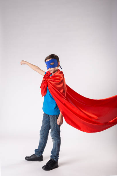 istock Super hero kid in red cape fluttering on wind 1013719504