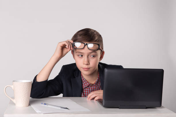 istock Young playful business kid looking at the laptop 1013721866
