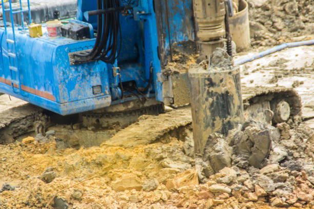 istock Hydraulic drilling machine is boring holes in the construction site for bored piles work. Bored piles are reinforced concrete elements cast into drilled holes, also known as replacement piles. 1013722062