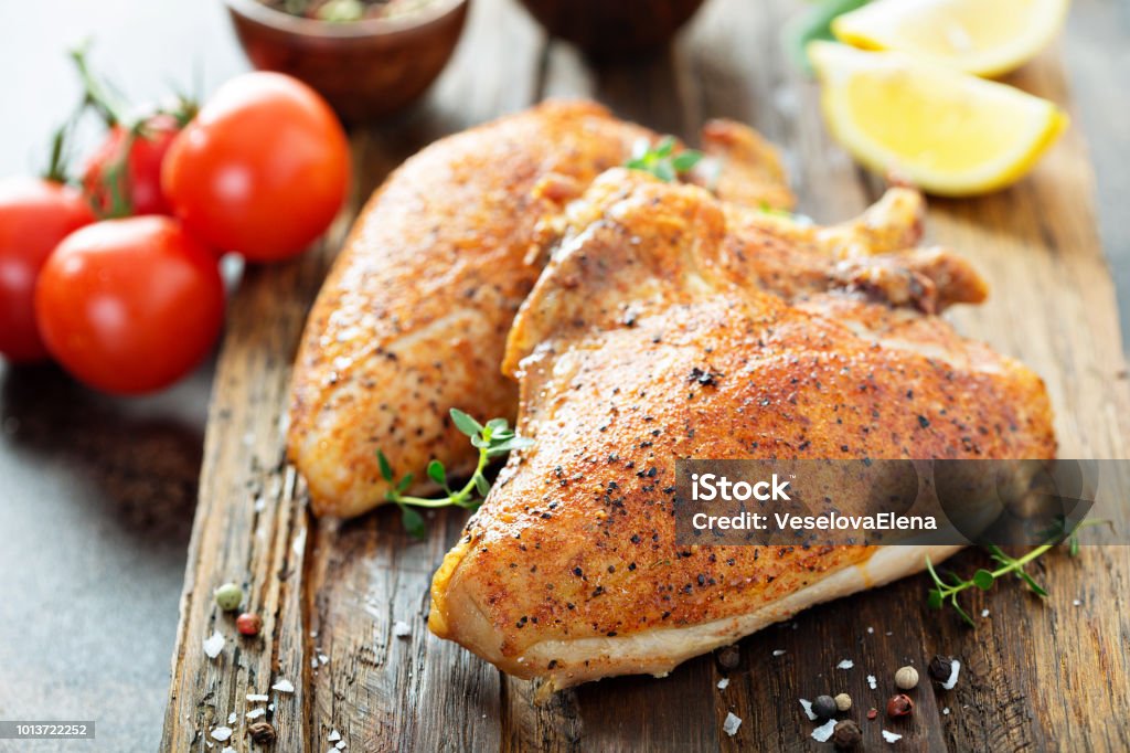 Petto di pollo alla griglia o affumicato con osso e pelle - Foto stock royalty-free di Petto di pollo